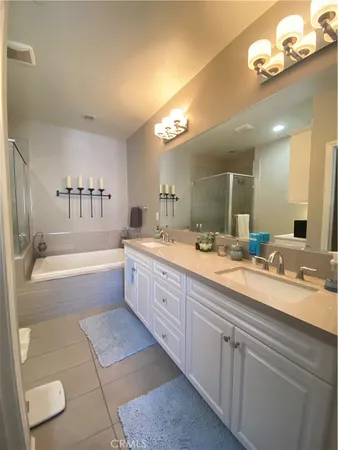 a spacious bathroom with a bathtub a double vanity sink and a mirror