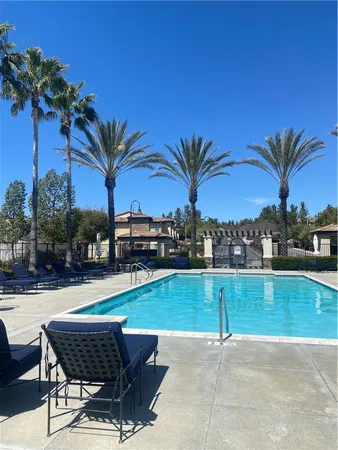 a swimming pool with outdoor seating and a garden