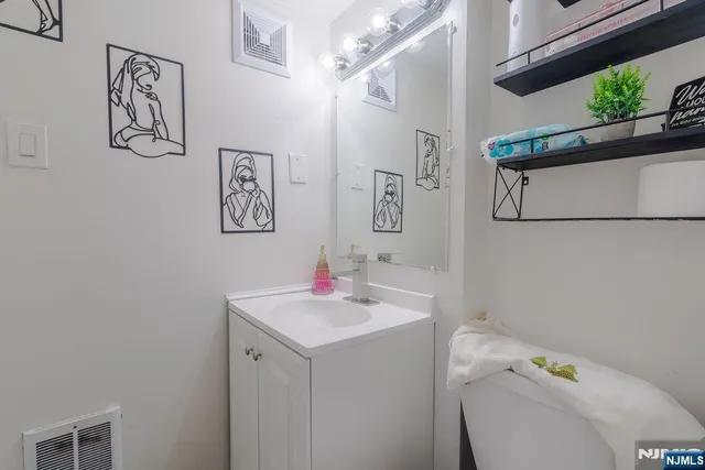 a bathroom with a sink toilet and a mirror