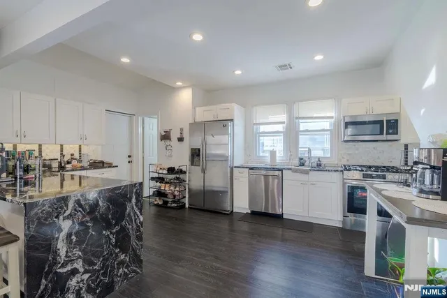 a kitchen with stainless steel appliances a refrigerator and a stove top oven