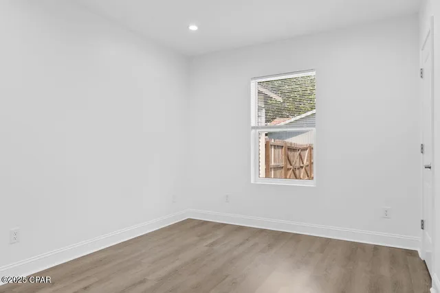 a bathroom with a toilet a sink a mirror and a window