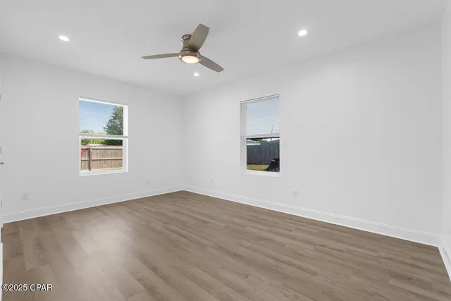 wooden floor in an empty room with a ceiling fan