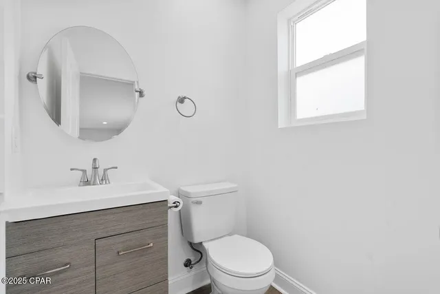 a bedroom with a large bed chandelier and a window