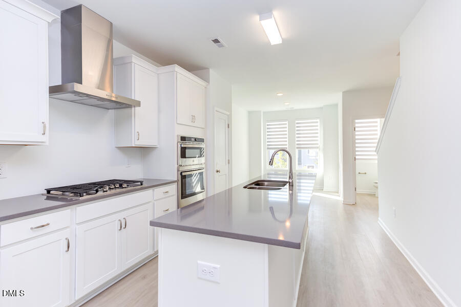1949 Robin Hill Lane Raleigh, NC 27610 - Photo 13 of 39 a kitchen with granite countertop a stove a sink and a white wooden cabinets