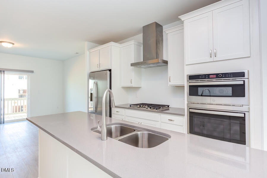 1949 Robin Hill Lane Raleigh, NC 27610 - Photo 20 of 39 a kitchen with white cabinets a sink and stainless steel appliances
