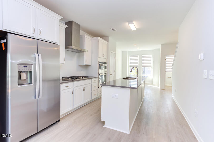 1949 Robin Hill Lane Raleigh, NC 27610 - Photo 10 of 39 a kitchen with white cabinets and stainless steel appliances