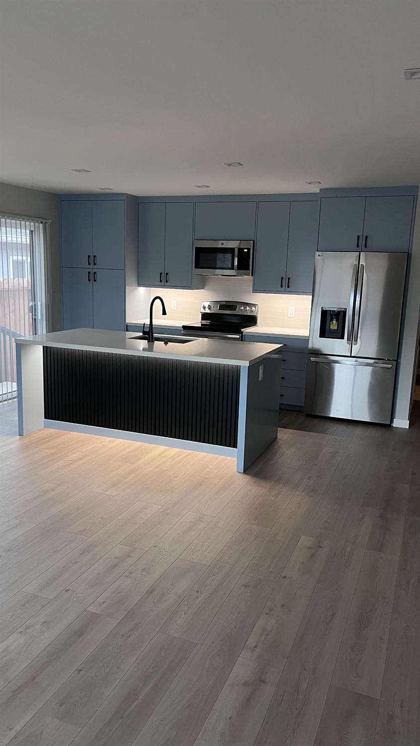 355 Sonoma Avenue Seaside, CA 93955 - Photo 18 of 32 a kitchen with stainless steel appliances kitchen island granite countertop a stove a sink and a refrigerator