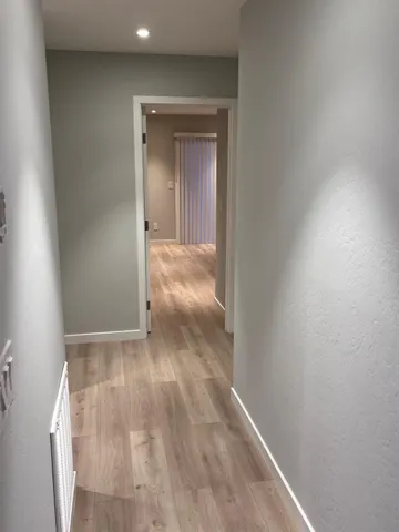 a view of hallway with wooden floor