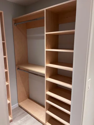a view of walk in closet with empty racks