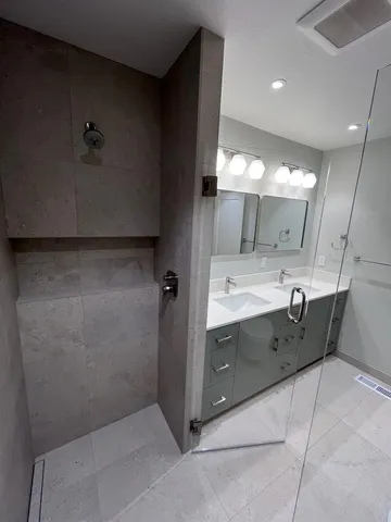 a bathroom with a double vanity sink a mirror and a bathtub