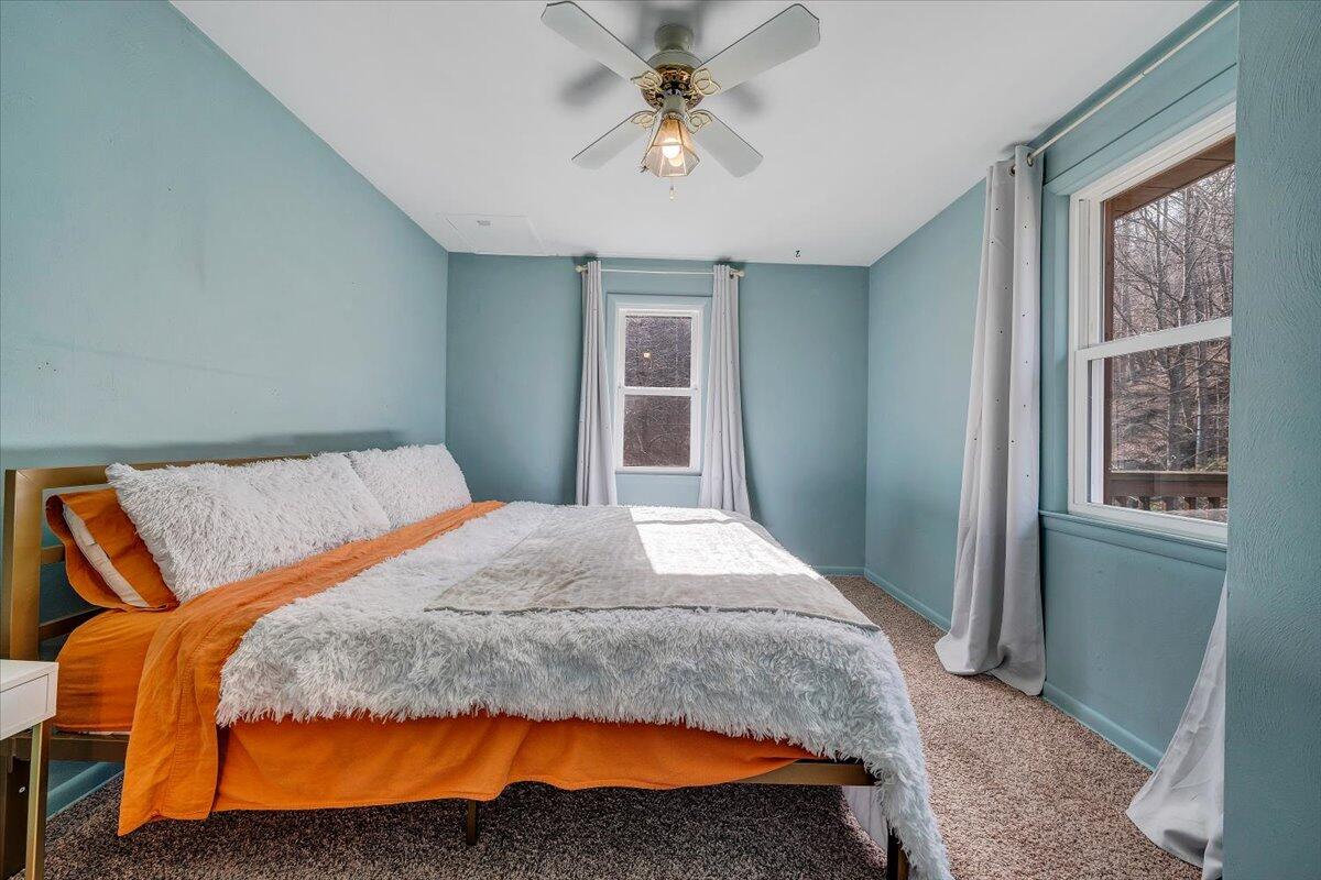 6847 Crowell Gap Road Boones Mill, VA 24065 - Photo 14 of 55 a bedroom with a large bed and a chandelier