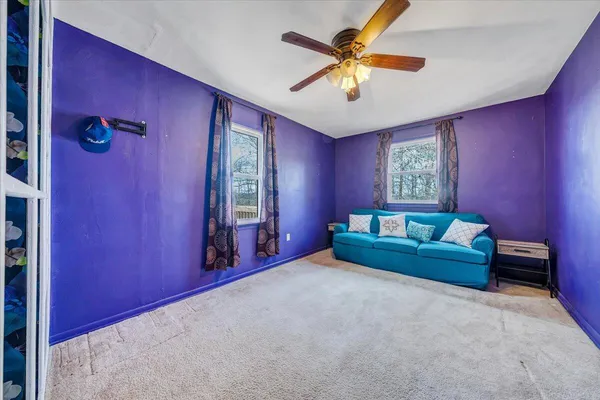 a living room with furniture and a ceiling fan