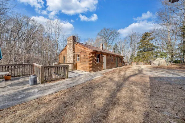 a view of a house with large trees and wooden fence
