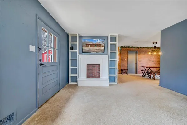 a view of a livingroom with an empty space and a fireplace