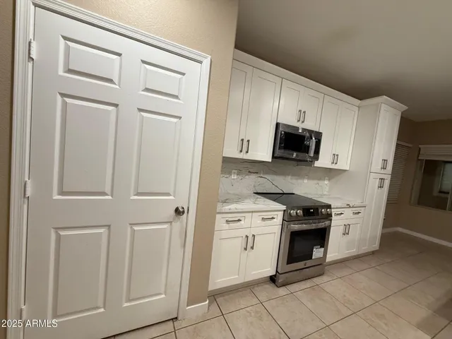a kitchen with stainless steel appliances granite countertop a sink a stove and a microwave