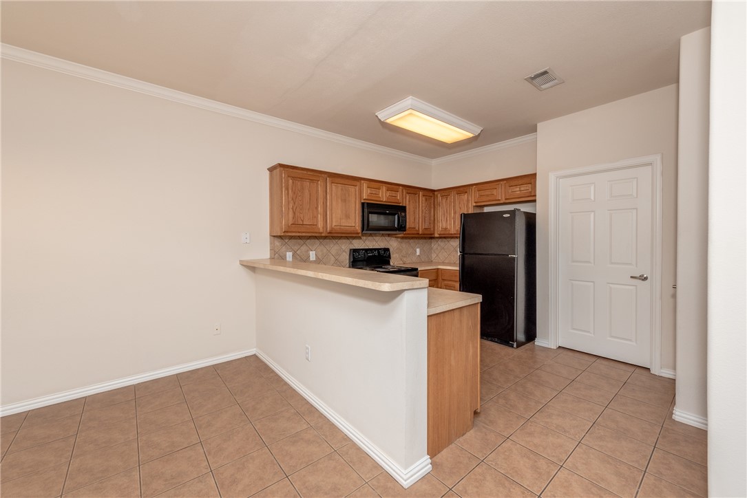 1001 Krenek Tap Road, Unit 1102 College Station, TX 77840 - Photo 6 of 26 a kitchen with a refrigerator a stove top oven and a refrigerator