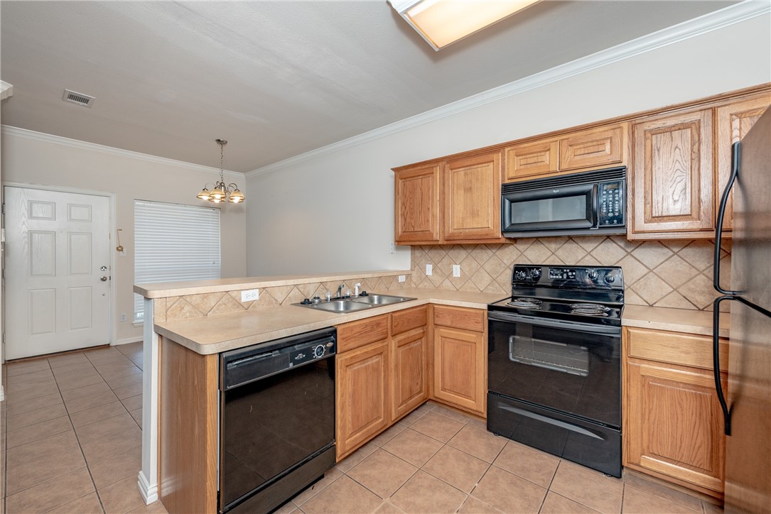 1001 Krenek Tap Road, Unit 1102 College Station, TX 77840 - Photo 7 of 26 a kitchen with stainless steel appliances granite countertop a stove top oven a sink dishwasher and a microwave oven with large cabinets