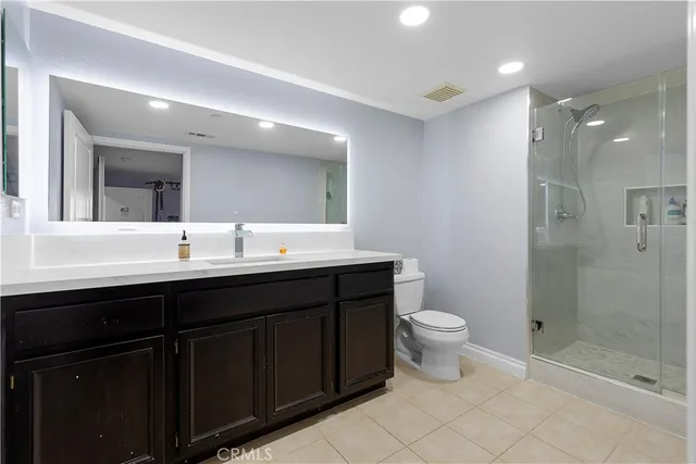 a bathroom with a double vanity sink toilet and shower