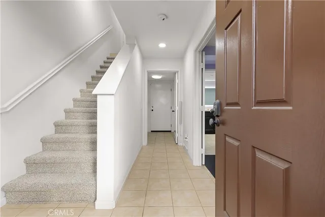a view of a hallway with wooden cabinets and staircase