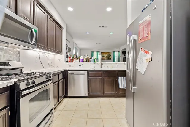 a kitchen with stainless steel appliances granite countertop a stove top oven and sink