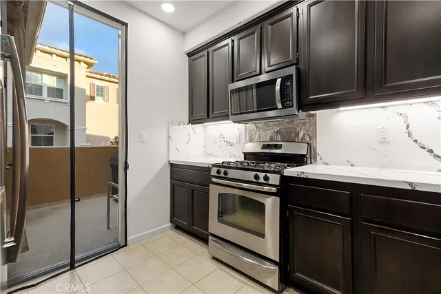 a kitchen with stainless steel appliances granite countertop a refrigerator stove and microwave