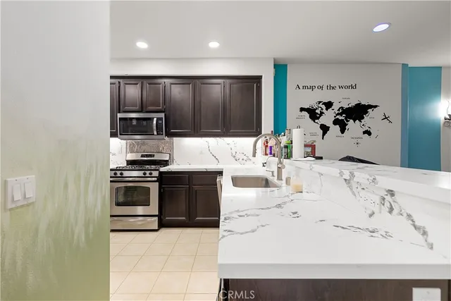 a kitchen with stainless steel appliances kitchen island granite countertop a refrigerator and a stove top oven