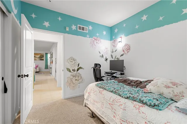 a bedroom with a large bed and a chandelier