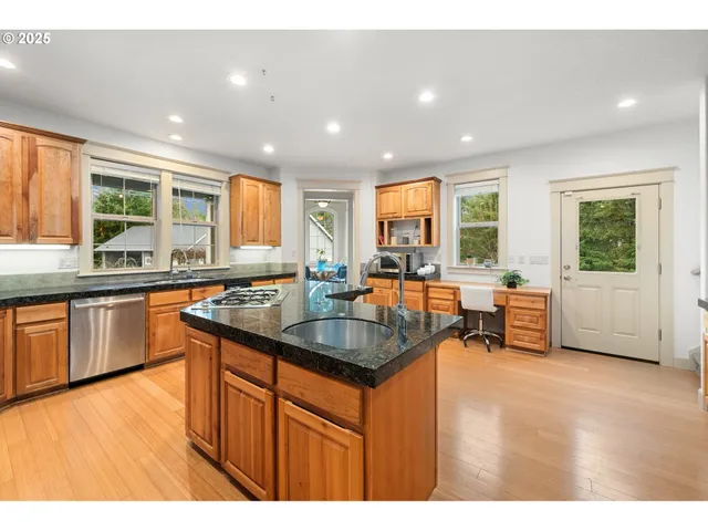 a kitchen with counter top space a sink a window and appliances