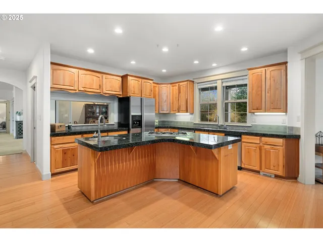 a kitchen with stainless steel appliances granite countertop a stove a sink and a refrigerator