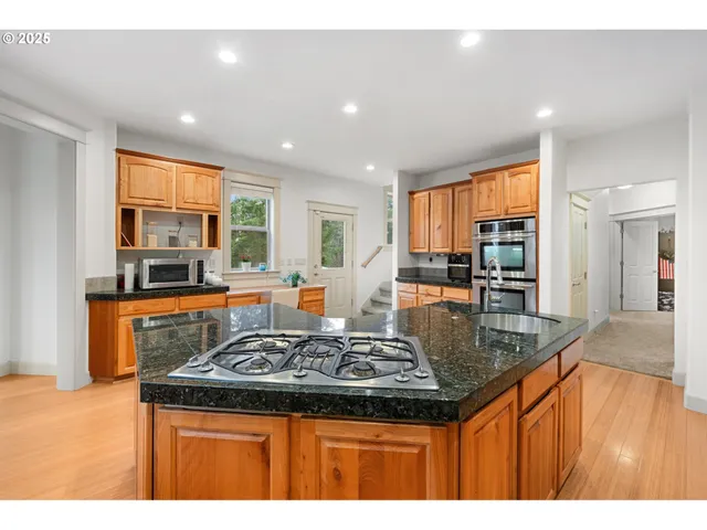 a kitchen with stainless steel appliances granite countertop a stove a sink a refrigerator and a counter top