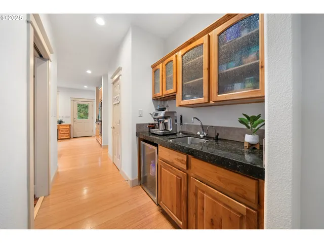 a hallway with cabinets a sink and a window
