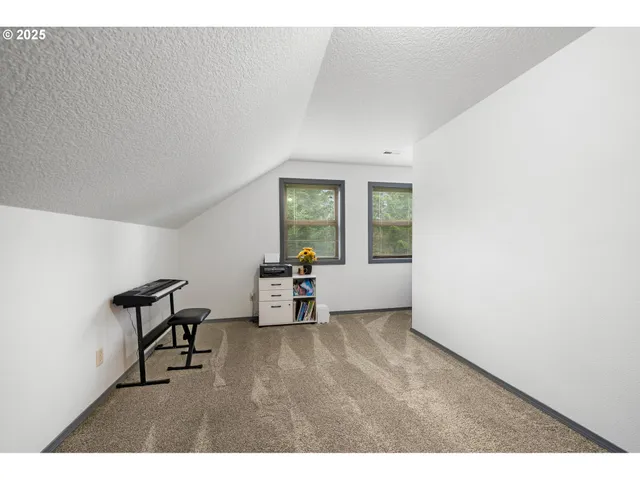 a view of an empty room with window and a fireplace