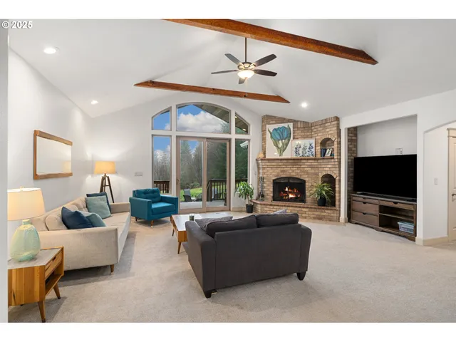 a living room with furniture a fireplace and a flat screen tv
