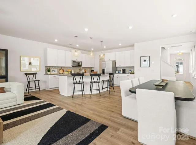 a living room with furniture and view of kitchen