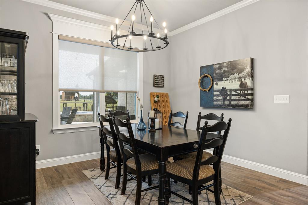 1800 Knox Road Tolar, TX 76476 - Photo 11 of 38 Dining area featuring wood-finish flooring, crown molding, and a substantial window with roller shades