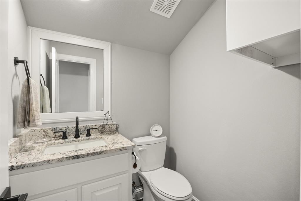 1800 Knox Road Tolar, TX 76476 - Photo 27 of 38 Bathroom #4 with white vanity featuring a granite countertop with an undermount sink, matte black faucet, framed mirror, and white cabinetry.