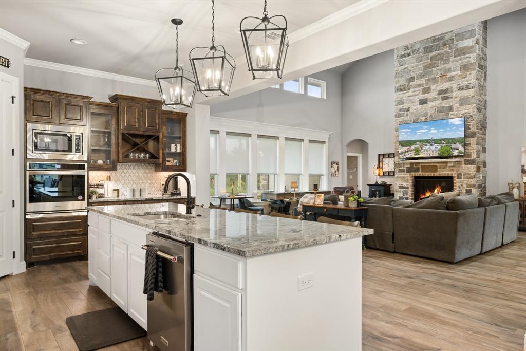 1800 Knox Road Tolar, TX 76476 - Photo 9 of 38 Gourmet kitchen featuring a large central island with a granite countertop, integrated sink, and stainless steel dishwasher
