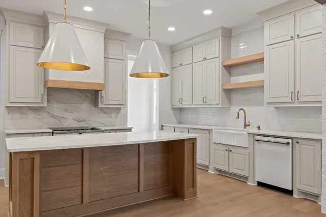 a kitchen with kitchen island granite countertop a sink a stove and a refrigerator