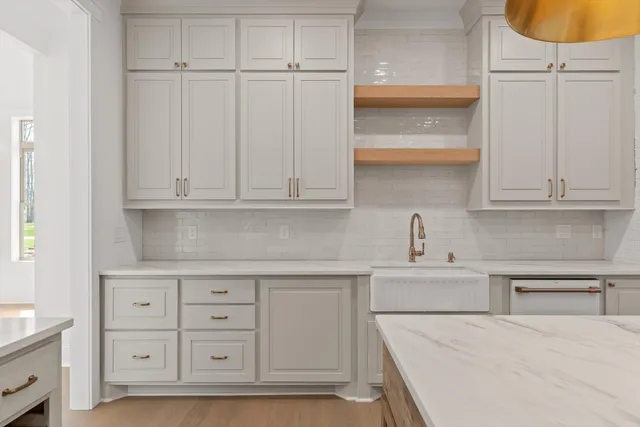 a kitchen with white cabinets and sink