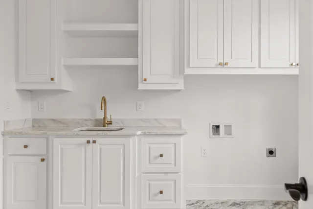 a kitchen with stainless steel appliances granite countertop white cabinets and a sink