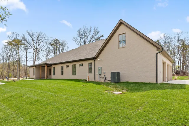 a view of a house with a yard and pathway