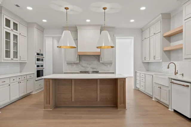a large kitchen with kitchen island a sink stainless steel appliances and cabinets