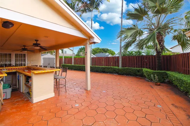 a view of a patio with a table and chairs under an umbrella