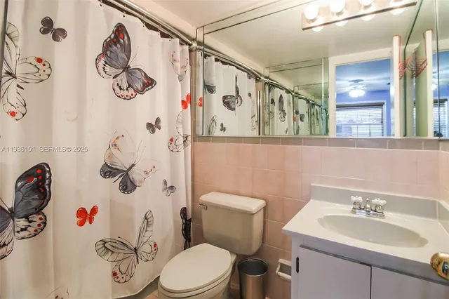 a white toilet sitting next to a bathroom sink