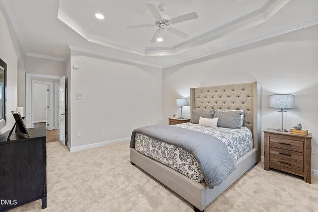 a spacious bedroom with a bed a couch and a potted plant