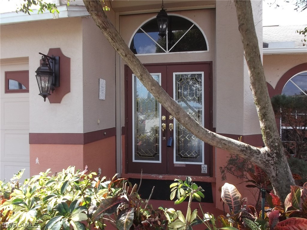 844 Rue Labeau Circle Fort Myers, FL 33913 - Photo 2 of 15 a front view of a house with lots of potted plants