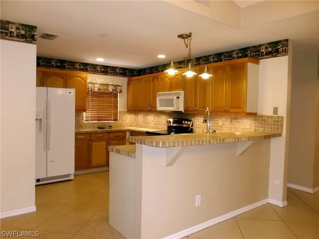 844 Rue Labeau Circle Fort Myers, FL 33913 - Photo 6 of 15 a kitchen with refrigerator and cabinets