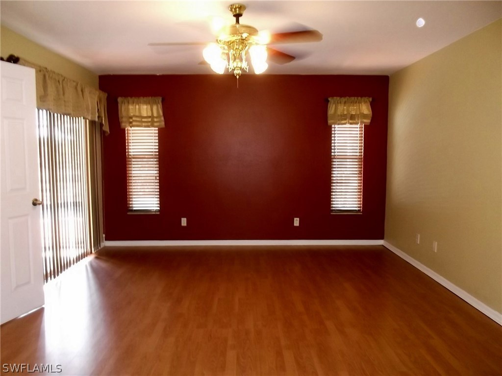 844 Rue Labeau Circle Fort Myers, FL 33913 - Photo 7 of 15 a view of an empty room with window and wooden floor