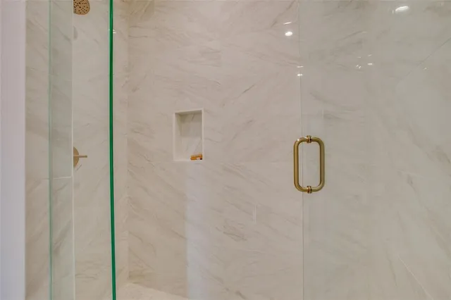 a bathroom with a granite countertop sink a mirror and a potted plant