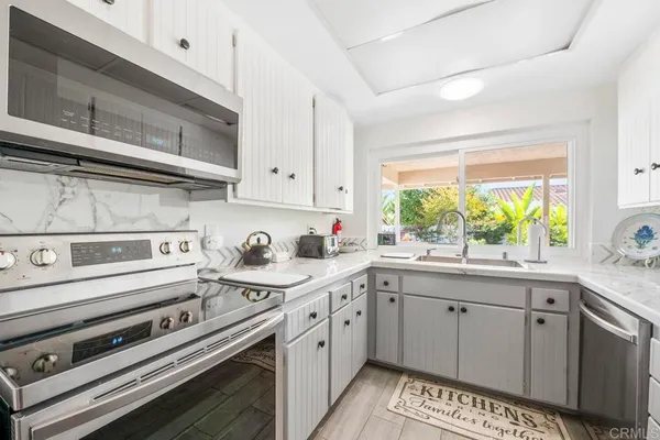 a kitchen with a stove a sink and a window